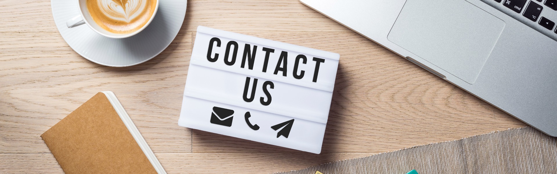 Contact us writing in lightbox lying on desk as flatlay