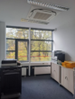 Ein Büro mit Druckern, Fenstern und Herbstblick. Helle Wände und dunkler Teppich.